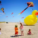 wildwoods international kite festival with family on beach pointing to kites in the sky